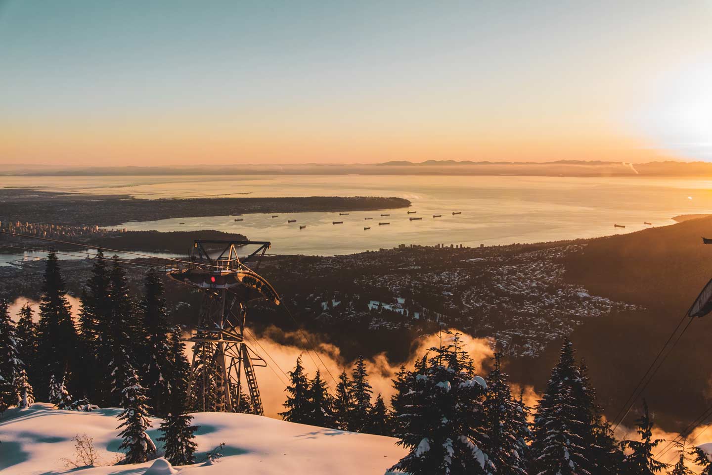 View from the top of a snowshoe resort overlooking a vast lake and small mountain town