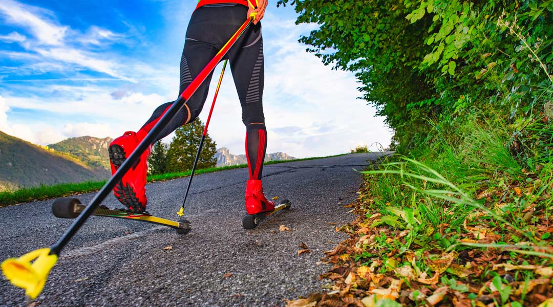 a close up of red roller skis being used on a mountain road