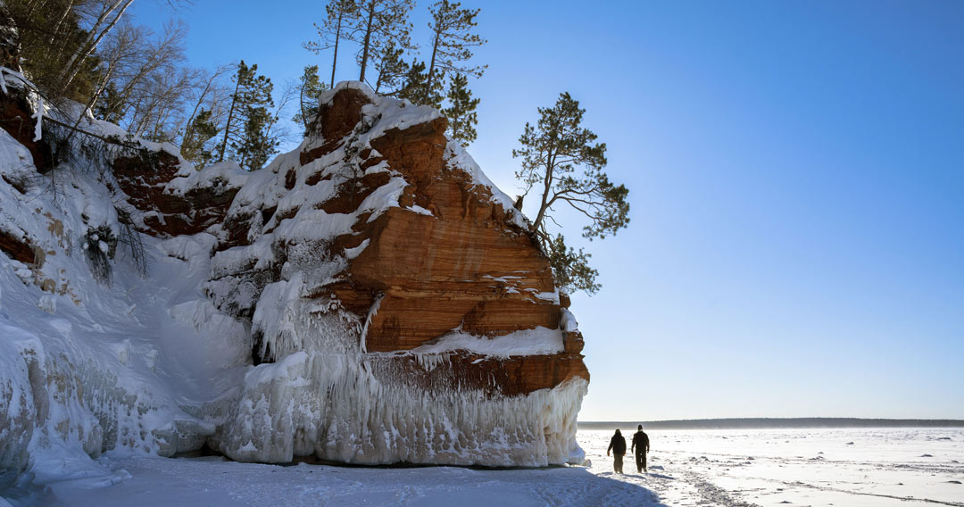 two people walking on frozen Lake Superior during winter at the Apostle Islands