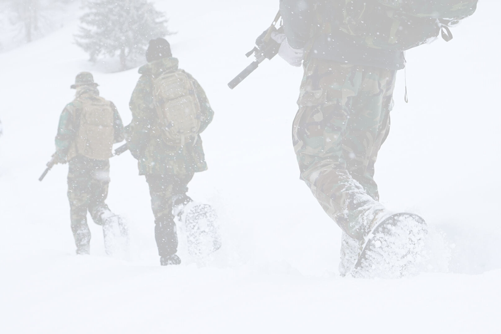 a tactical team of four hiking through a winter landscape while wearing special snowshoes designed by Snowfoot